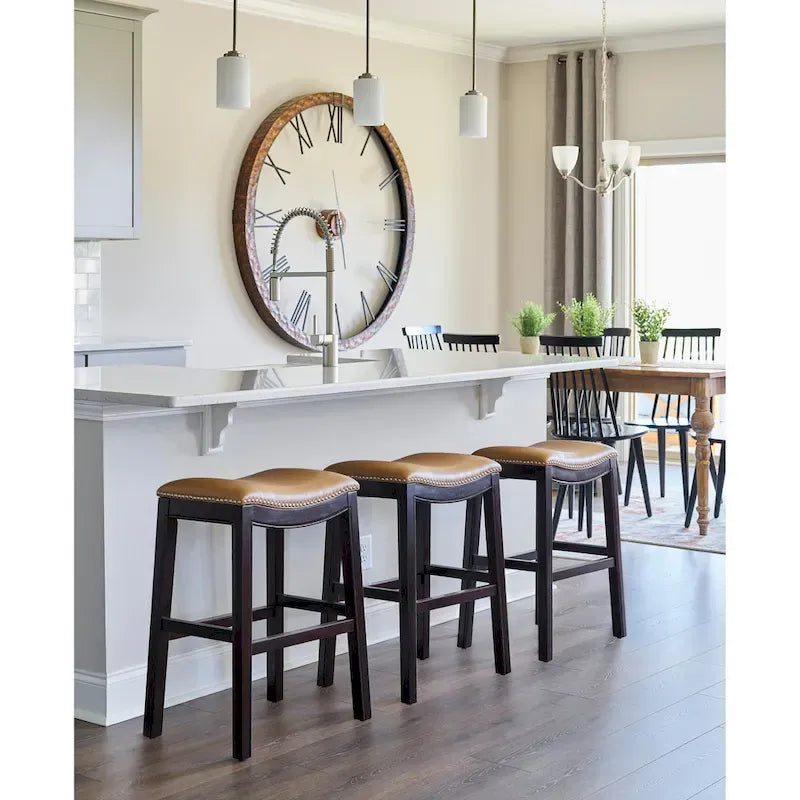 Tabouret de bar de 66 cm de haut, assise en forme de selle, similicuir, détails cloutés, bois massif, repose-pieds en métal, expresso et tan, usage individuel